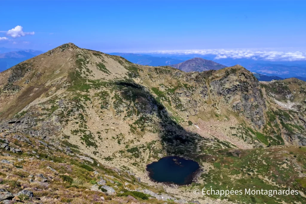 Je descends vers le col, en contrebas duquel je découvre l'étang Supérieur. À l'arrière, le Mont Fourcat marque l'extrémité ouest du massif.